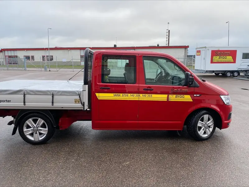 Sahlins Byggs röda servicebil med flak på en parkering i Vara