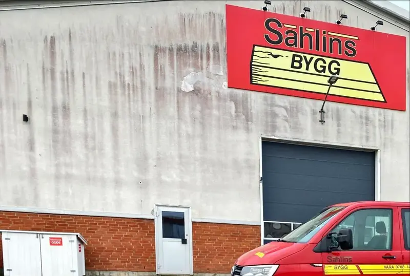 Sahlins Byggs lokal i Vara med skylt och företagets röda servicebil